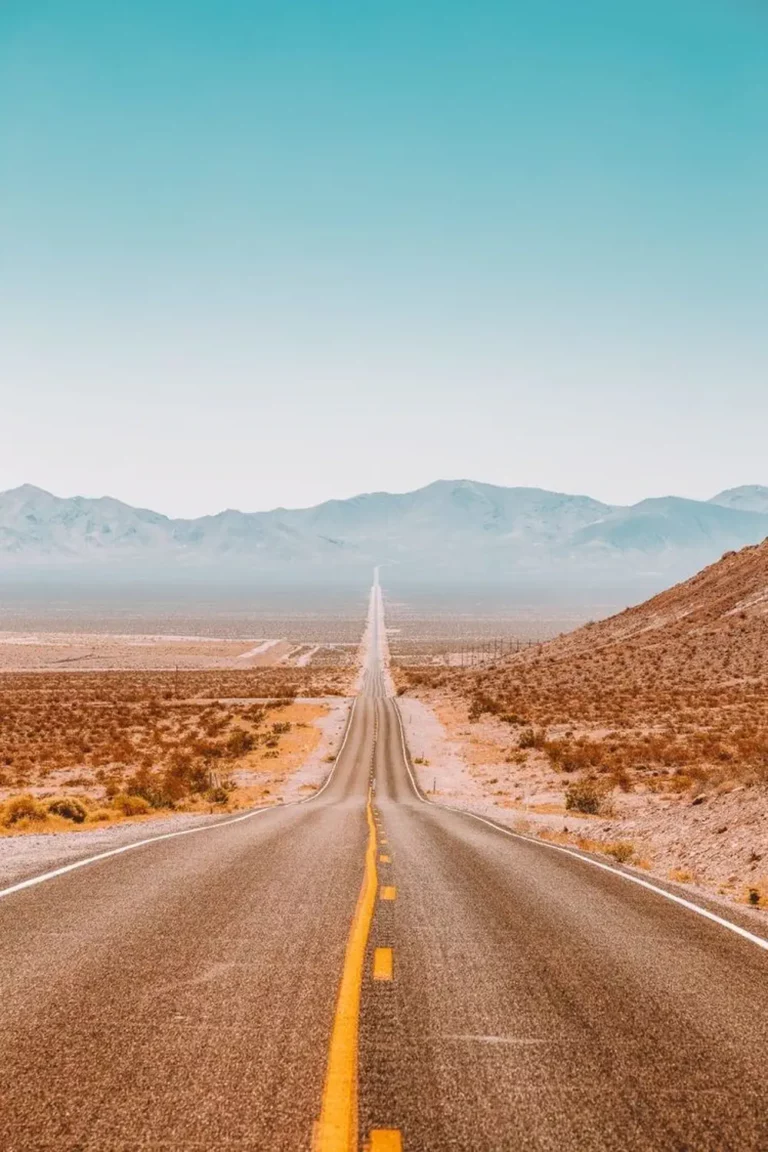 Face à une route droite dans le desert américain la ligne jaune ouvre le chemin